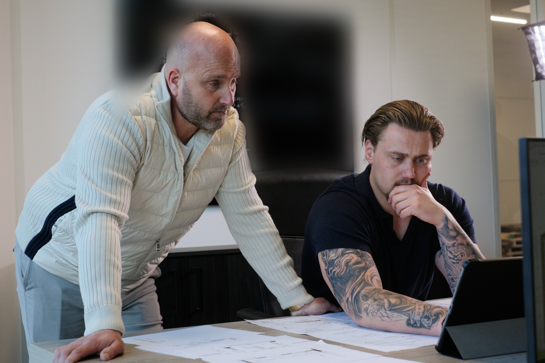Alex en collega in overleg achter de tekening
